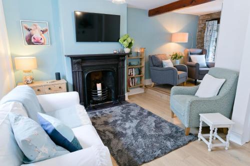 a living room with a couch and a fireplace at Melvin Cottage in Beaumaris