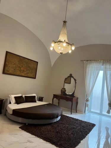 een slaapkamer met een bed en een kroonluchter bij B&B Carlo di Borbone in Caserta