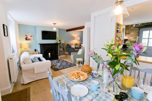 a living room with a table with a plate of food at Melvin Cottage in Beaumaris