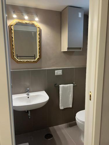 een badkamer met een wastafel, een spiegel en een toilet bij B&B Carlo di Borbone in Caserta