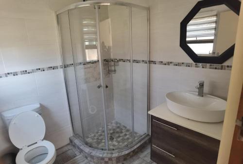 a bathroom with a shower and a toilet and a sink at Lasev Resort in Pretoria