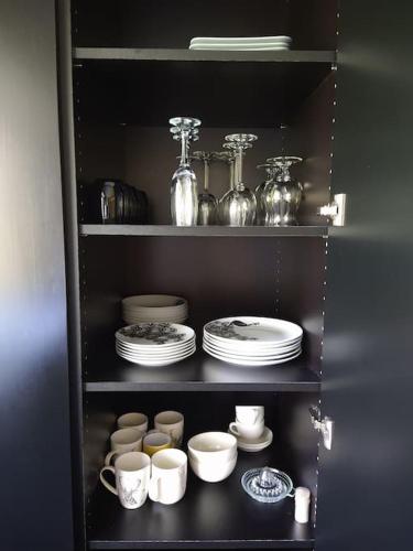 a shelf filled with plates and cups and dishes at Côté jardin in Dison