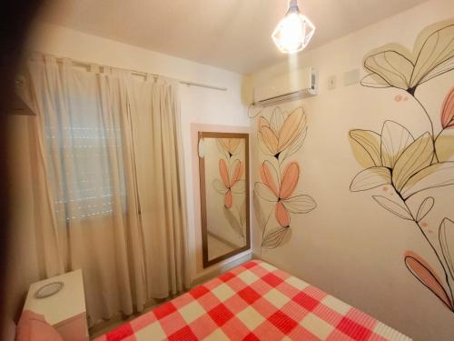 a bedroom with a mirror and flowers painted on the wall at casa flores in Foz do Iguaçu