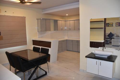 - une cuisine avec une table, un évier et un comptoir dans l'établissement The Butterfly - Ramachandra Nagar, à Vijayawada