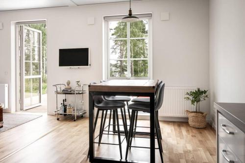 uma cozinha com um bar com bancos num quarto em Udden, Amazing house with lake view em Mullsjö