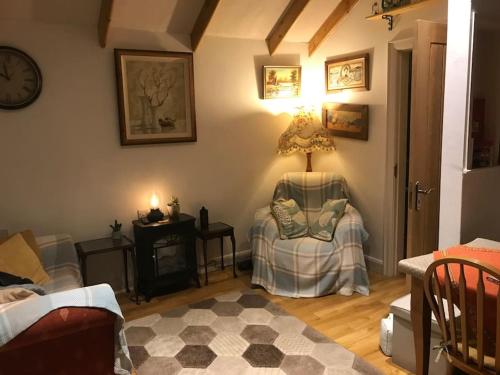 a living room with a chair and a lamp on the wall at Lovely cottage in Lower Bracky