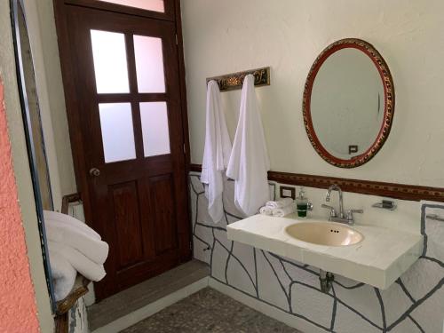 een badkamer met een wastafel en een spiegel bij Mesón Yollotl in Puebla