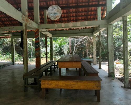 uma mesa de madeira no interior de um pavilhão em Quarto na floresta com saída no igarapé - Espaço Caminho das pedras em Alter do Chão