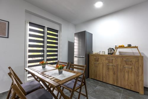 a kitchen with a table and chairs and a refrigerator at Villa Ana Bački Petrovac in Bački Petrovac