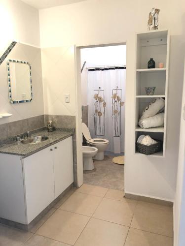 a bathroom with a toilet and a sink and a mirror at Complejo Los Aromitos 1 in Río Ceballos