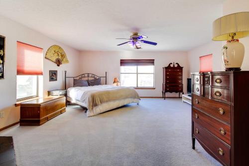 a bedroom with a bed and a dresser and a ceiling fan at Albuquerque Home with Spacious Yard and Fire Pit! in Albuquerque