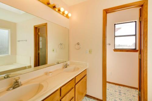 a bathroom with two sinks and a large mirror at Albuquerque Home with Spacious Yard and Fire Pit! in Albuquerque