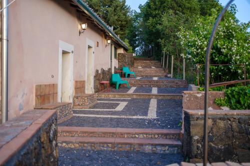 a row of steps with a green bench and a building at Il Giardino di Efesto in Biancavilla