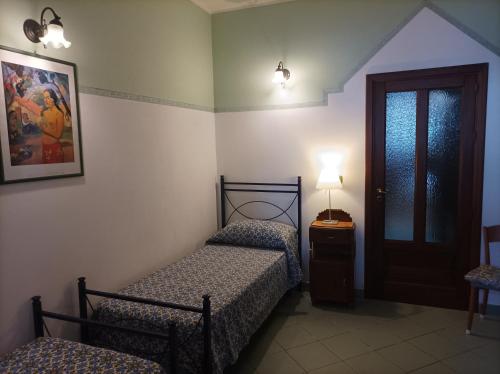 a bedroom with two beds and a lamp and a door at Aimola in Avola