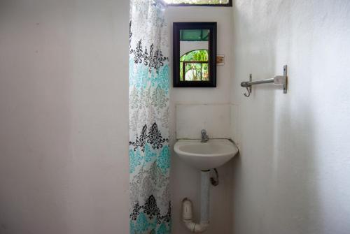 een badkamer met een wastafel en een douchegordijn bij Casa Sarah in Nosara