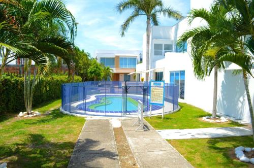 - une piscine dans une cour avec des palmiers dans l'établissement CASA EN CONDOMINIO, GIRARDOT, à Girardot