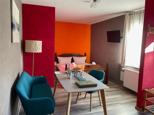 Cette chambre comprend une table, des chaises et un lit. dans l'établissement Trattoria & Apartments - Casa da Enzo, à Goslar