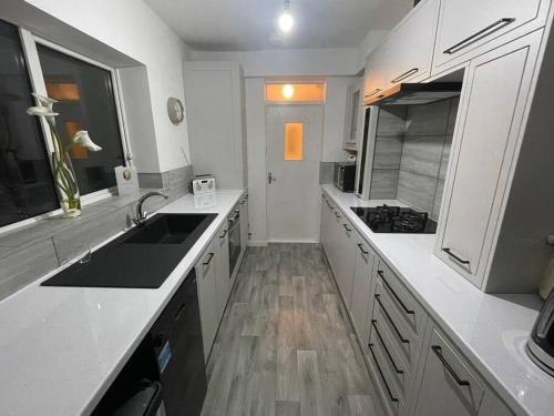 a white kitchen with a sink and a stove at 3 Bedroom Apartment with Golf Course View in Newcastle upon Tyne