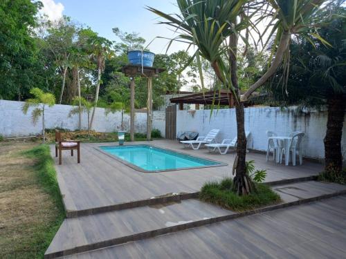 un patio trasero con piscina y terraza de madera en CASA DE PRAIA CAJUEIRO ALTER, en Alter do Chao