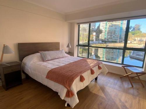 1 dormitorio con cama y ventana grande en Condominio Puerto Pacífico, (Coraceros), Viña, en Viña del Mar