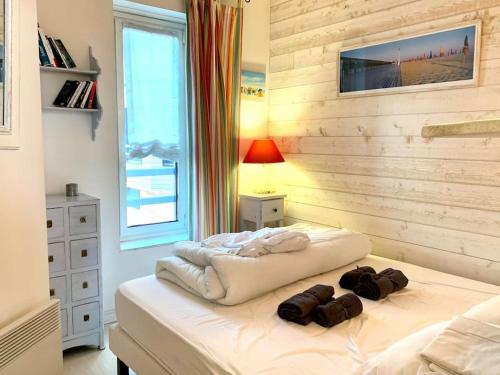 une chambre avec un lit avec deux sacs dessus dans l'établissement Bel appartement vue mer avec parking gratuit, à Deauville