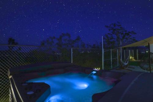 a backyard swimming pool at night with a fence at Perfect Getaway withAmazing Views at Joshua Tree home in Yucca Valley