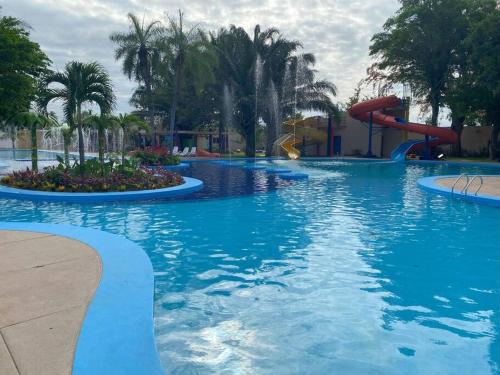 a large swimming pool with a water slide at a resort at Hermosa casa en cond. privado in Santa Cruz de la Sierra