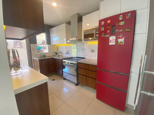 una cocina con una nevera roja con imanes. en Hermosa casa en cond. privado en Santa Cruz de la Sierra