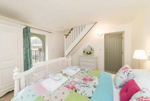 een slaapkamer met een bed en een trap bij Folly - Middleton Hall Estate in Belford