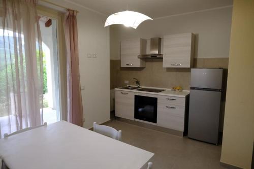 cocina con mesa, nevera y ventana en Casa Celeste, en Nocera Umbra