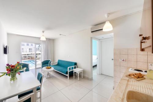 a kitchen and living room with a couch and a table at Mia Hotel Apartment in Ayia Napa