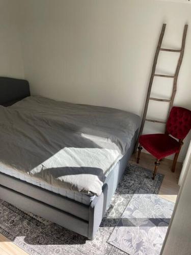 1 dormitorio con cama, escalera y silla en Historisk Charm i Hjärtat av Gamla Stan Kalmar, en Kalmar