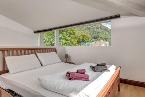 sypialnia z białym łóżkiem i 2 ręcznikami w obiekcie Splendido attico per chi ama escursioni nella natura w mieście Grono
