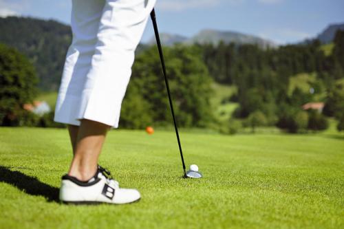 a person is playing golf on a field at DIANA Naturpark Hotel - Partnerbetrieb von "Oberstaufen PLUS GOLF" in Oberstaufen