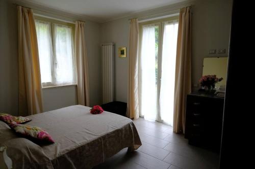 1 dormitorio con 1 cama y 2 ventanas grandes en Casa Celeste, en Nocera Umbra