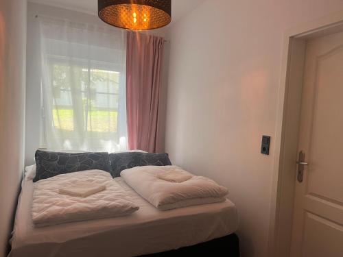 un letto con due cuscini sopra in una stanza con finestra di Wormis Apartment Heideblick bei Luckau a Heideblick