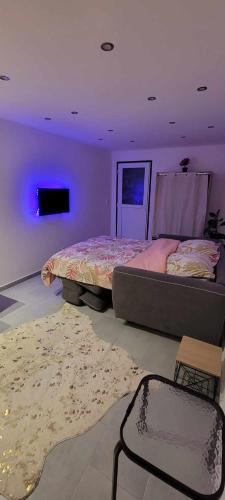 a bedroom with a large bed and a purple light at charmant studio in Saint-Hilaire-du-Rosier