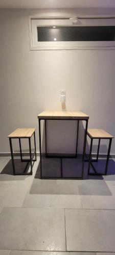 a table and two benches in a room at charmant studio in Saint-Hilaire-du-Rosier