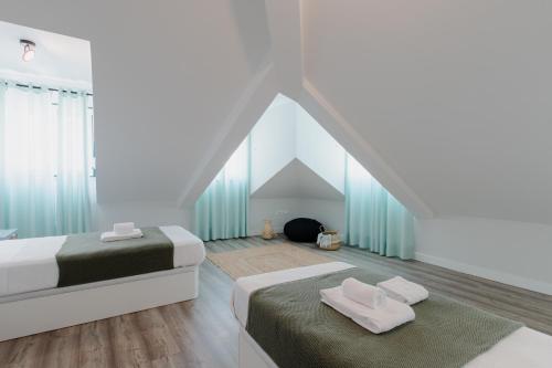 een slaapkamer op zolder met 2 bedden en een dak bij Casa do Azulejo II in Setúbal
