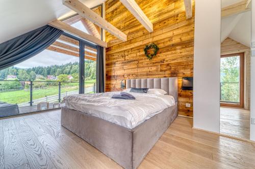 a bedroom with a bed in a room with wooden walls at Chalet Pine Tree in Zawoja