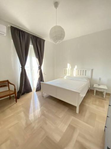 a white bedroom with a bed and a table at Casa Frida in Bitonto