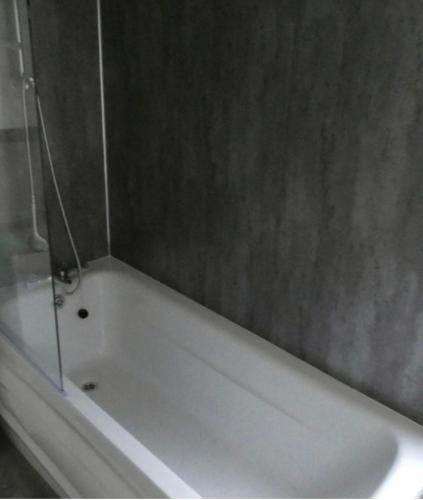 a white bath tub with a shower in a bathroom at Langford Lodge in Great Billing