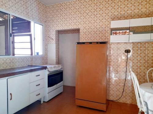a kitchen with a refrigerator and a window at Casa da Vó Nair in Barra Bonita