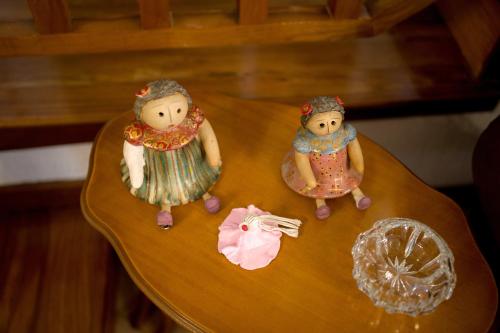 three dolls are sitting on a wooden table at Archontiko Alexandros Luxury Suites in Kardiá