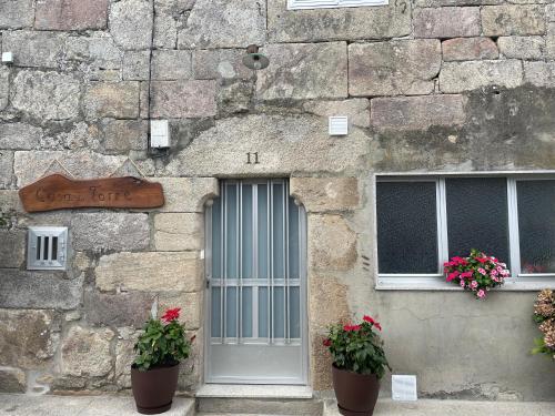 un edificio de piedra con dos macetas al lado de una puerta en Casa da Torre 