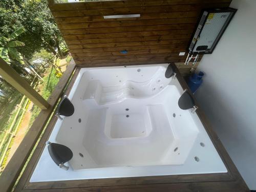 bañera blanca en una habitación con 2 sillas en Cabañas Campestres Bosque Encantado, en Guatapé