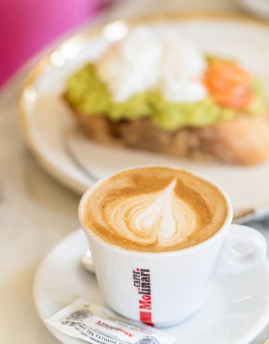 a cup of coffee on a plate with a plate of food at Santa Lucia Boutique Hotel in Santa Luċija