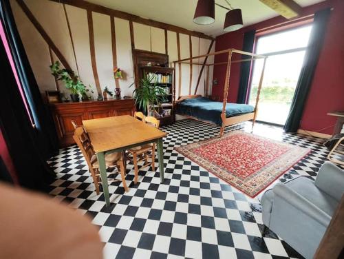 a living room with a table and a checkered floor at Chambre spacieuse avec vue sur clocher in Verchin