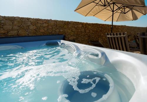 a water fountain in a pool with an umbrella at Santa Lucia Boutique Hotel in Santa Luċija