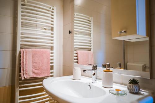a bathroom with a sink and a mirror and pink towels at Apartman Marta in Zavalatica
